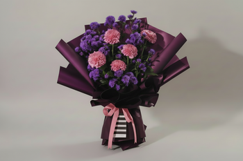 A striking bouquet featuring full pink chrysanthemums and delicate purple asters. It is elegantly wrapped in deep purple paper with a modern black and white striped accent at the base. The arrangement is tied with a pink ribbon bow, creating a full, rounded shape. This sophisticated bouquet is perfect for birthdays, anniversaries, or as a thoughtful thank-you gesture.