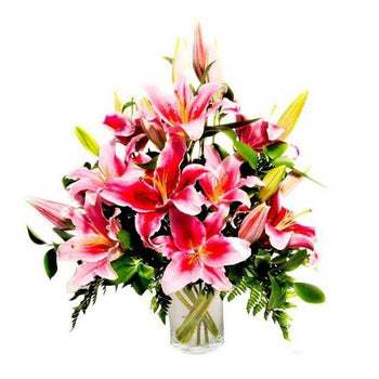 Table Arrangement Of Pink Lilies And Greens in Vase