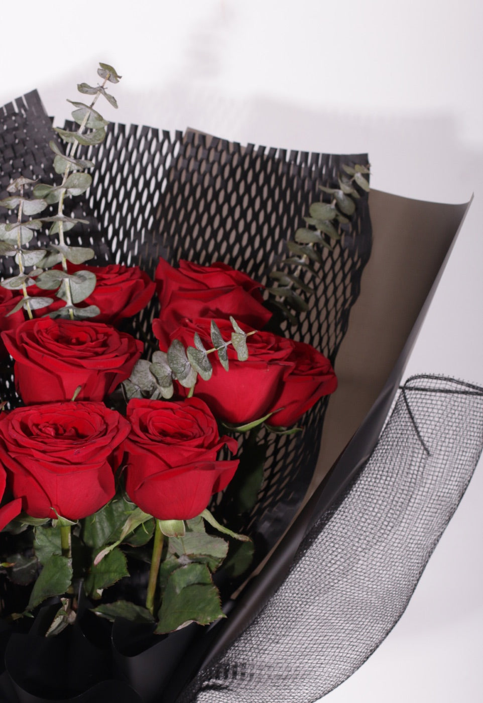 Fresh red rose bouquet hand-wrapped in black paper by Outerbloom